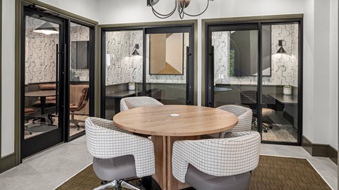 A modern conference room with a round table and chairs.