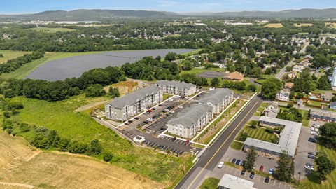 A large building complex with a parking lot in front of it.