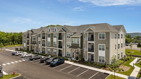 A large apartment complex with a parking lot in front.