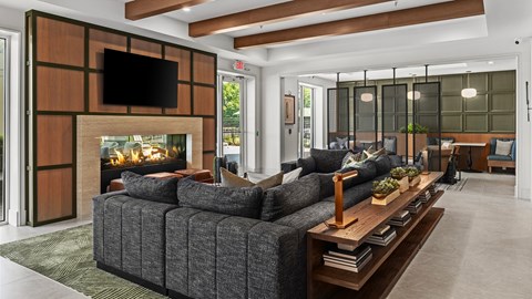 A modern living room with a grey sofa and a fireplace.