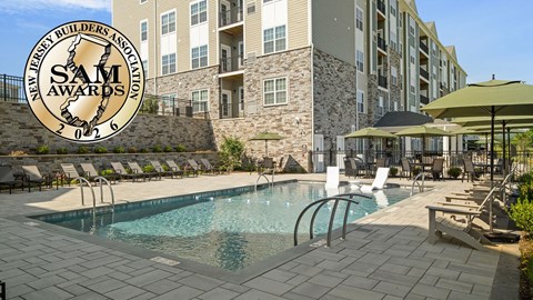 Pool area of Monte View at Pohatcong with badge showing the community won a 2026 New Jersey Builders Association Sales and Marketing Award.