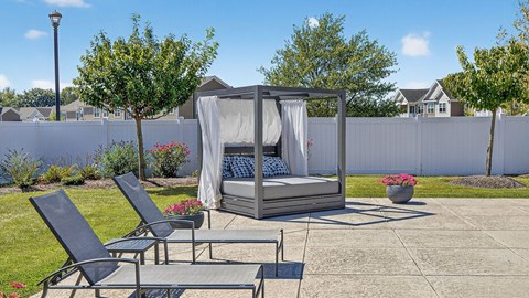 A patio with a hot tub and chairs.