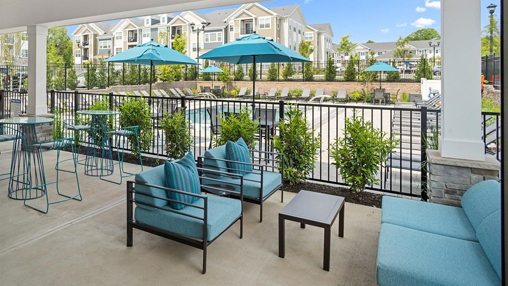 a patio with couches and tables and umbrellas