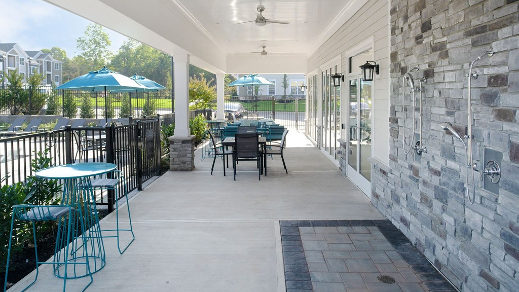 a covered patio with tables and chairs and umbrellas