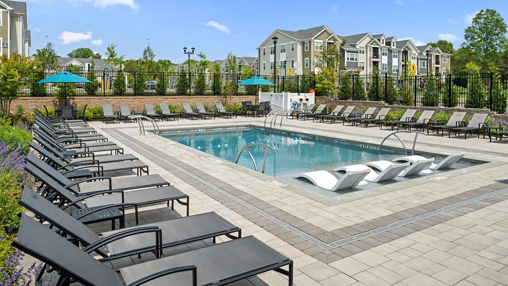 a swimming pool with lounge chairs around it