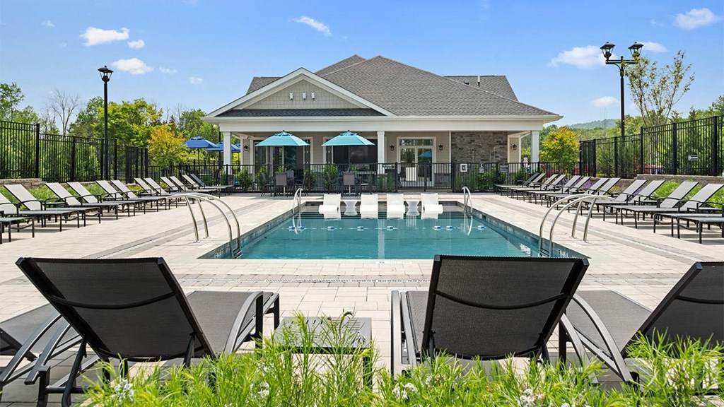 a pool with lounge chairs and a building in the background