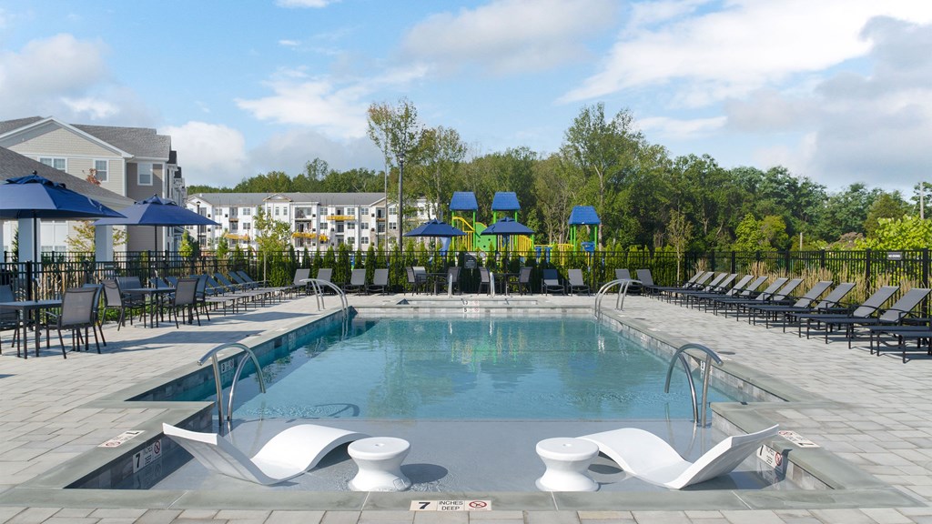 a swimming pool with chairs and umbrellas at the resort