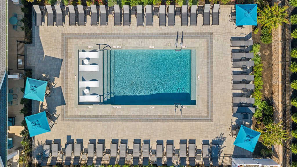 a swimming pool with umbrellas and chairs next to a pool