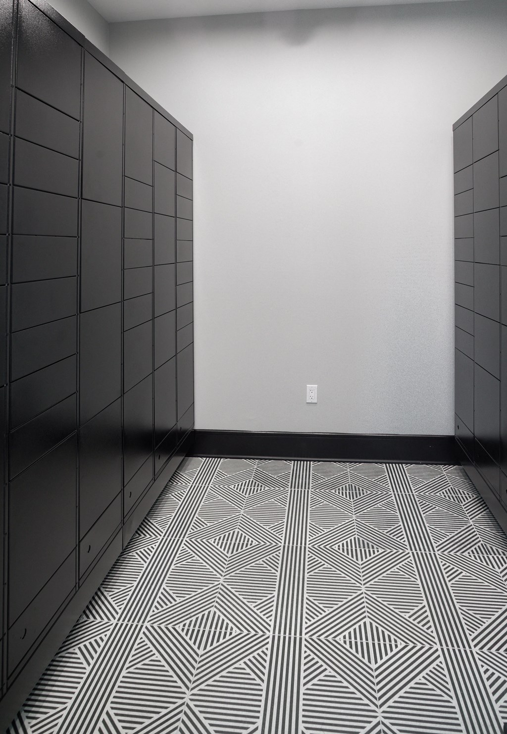 a room with black cabinets and a white wall and a patterned floor