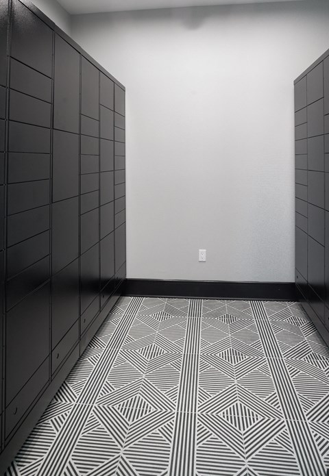 a room with black cabinets and a white wall and a patterned floor