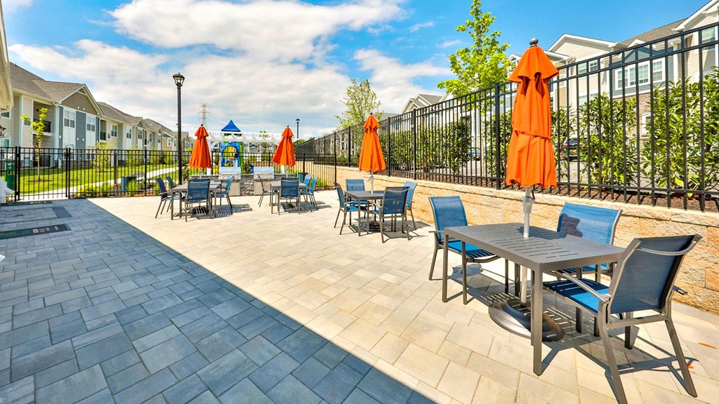 an outdoor patio with tables and chairs and umbrellas