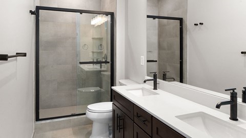 A white toilet sits in a bathroom next to a sink.
