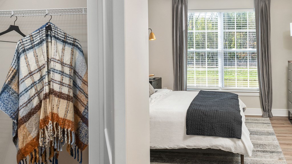 a bedroom with a bed and a blanket hanging on a wall