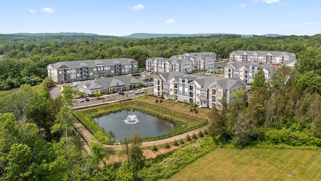 an aerial view of a resort with a pond and buildings