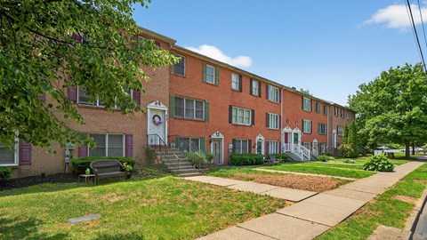 A red brick building with a white door and windows.
