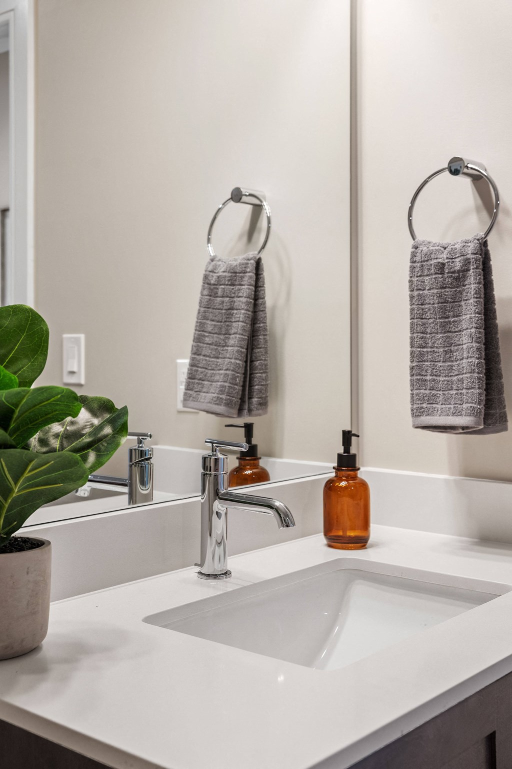 a bathroom with a sink and a mirror with a towel and a soap dispenser