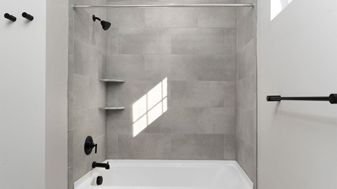 A modern bathroom with a walk-in shower and a window.