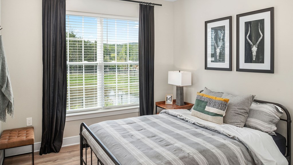 an overview of a bedroom with a bed and two windows