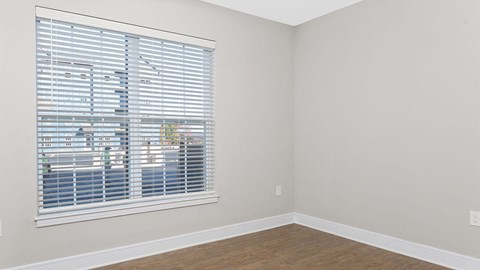 A room with a window covered in blinds.