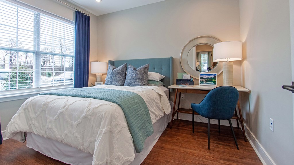 a bedroom with a bed and a desk with a chair