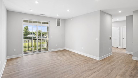 a living room with a large window and a door to a balcony