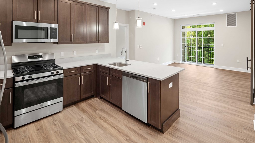 an empty kitchen with wooden cabinets and stainless steel appliances