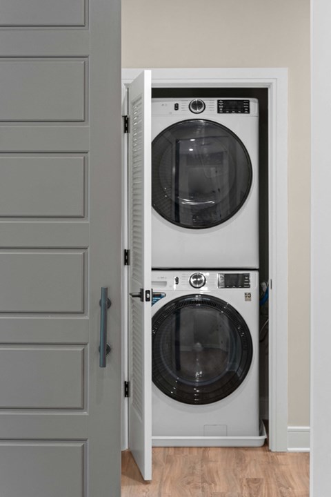 a white front loading washer and dryer in a closet