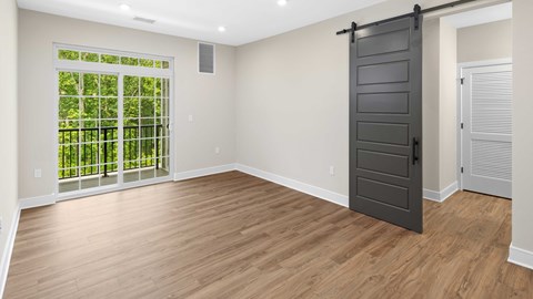 an empty living room with a black door and a window