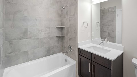 a bathroom with a sink and a tub and a mirror