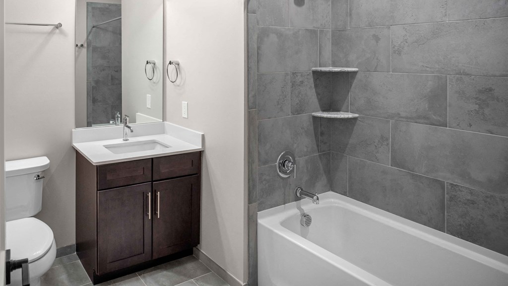 a bathroom with a tub sink and toilet and a mirror