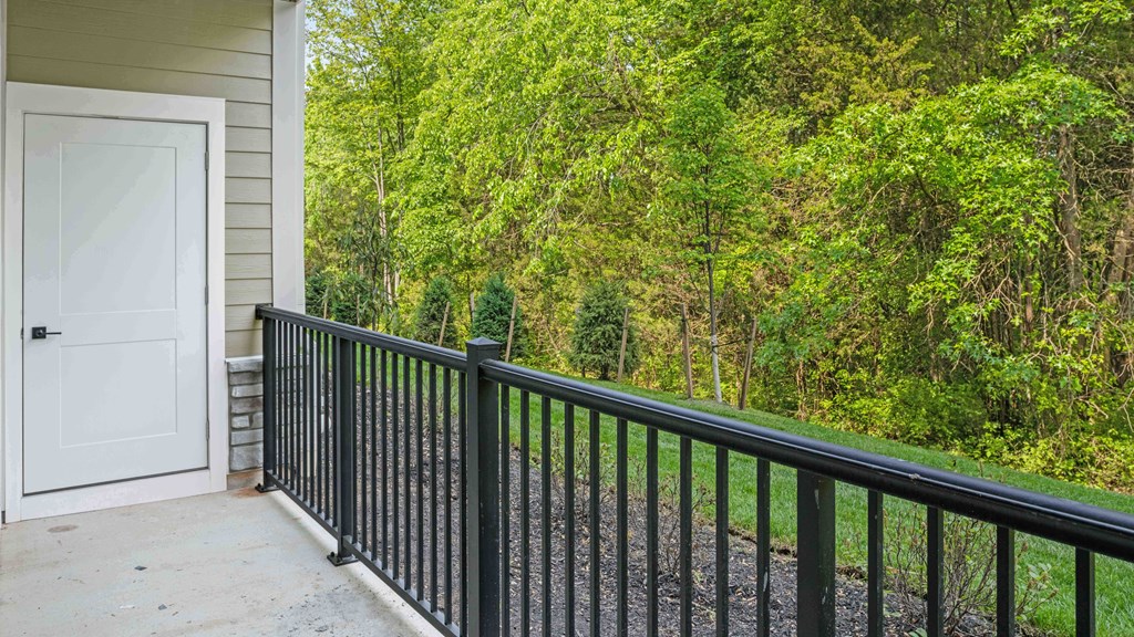 the deck of a house with a white door and railings