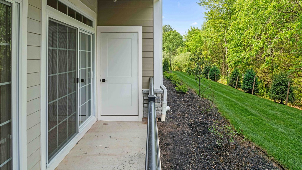 front door of a home with grass and trees