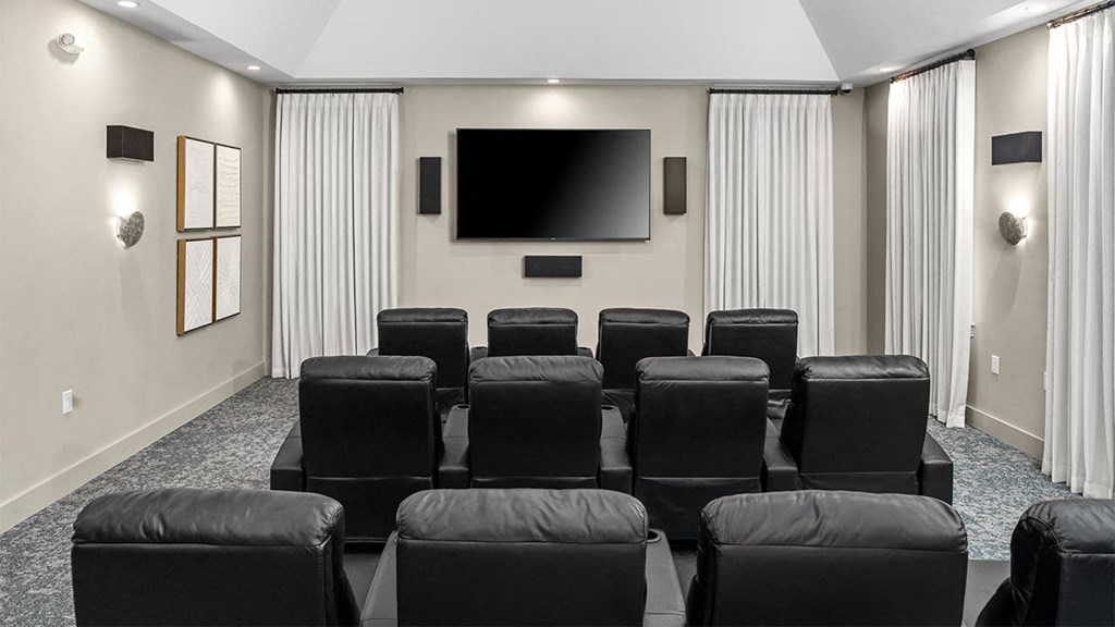 a conference room with black chairs and a television