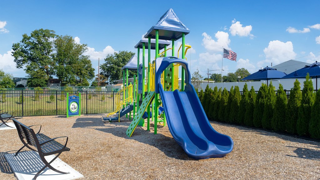 a playground with a blue slide and green and blue playset