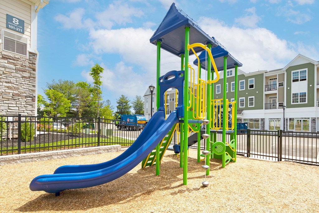 a playground with a blue slide at an apartment complex