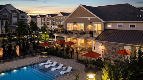 A pool surrounded by lounge chairs and umbrellas at a resort.