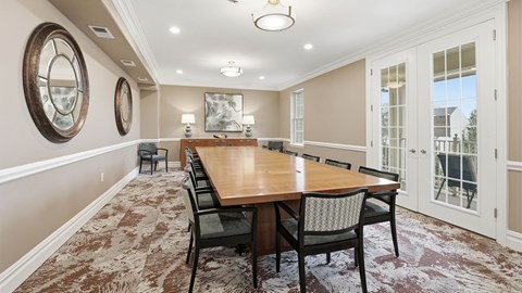 Multipurpose room with a long wooden table and chairs.