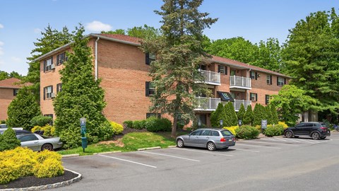 A parking lot in front of a brick apartment building.