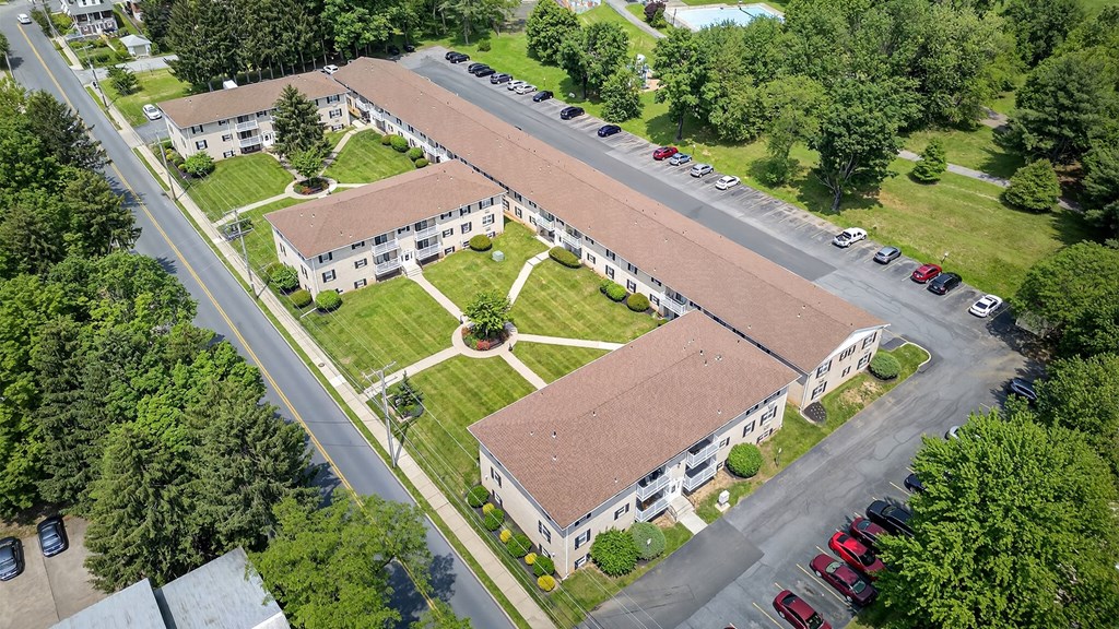An aerial view of a building with a parking lot in front.