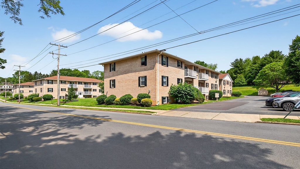 A street view of a residential area with houses and cars.