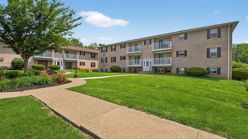 Apartment complex with a walkway in front.