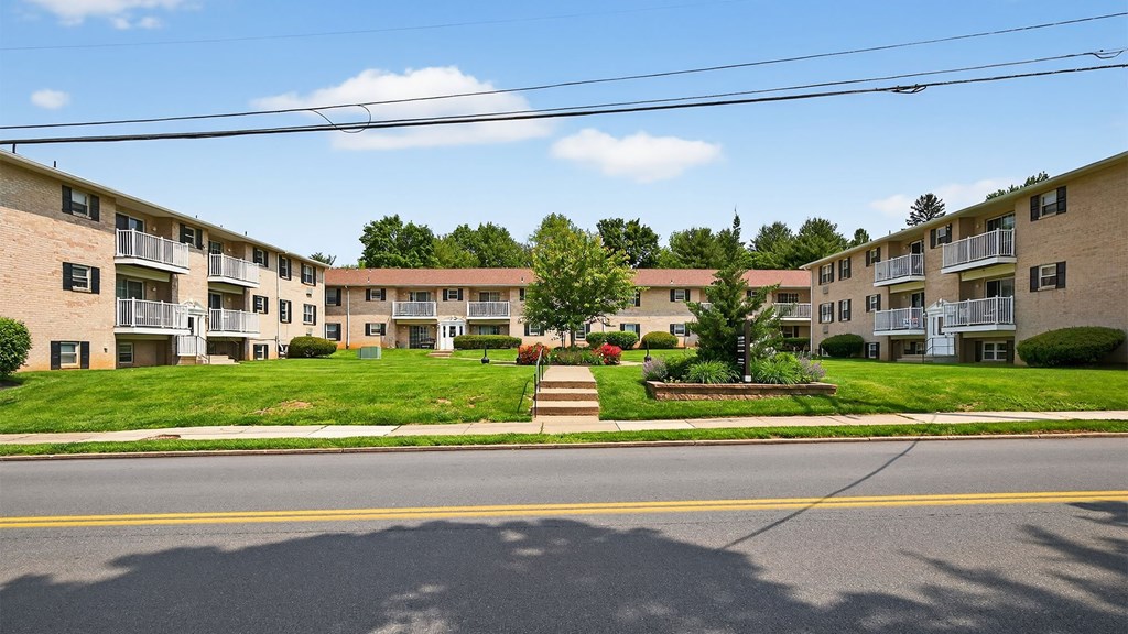 Apartment complex with green lawns and trees.