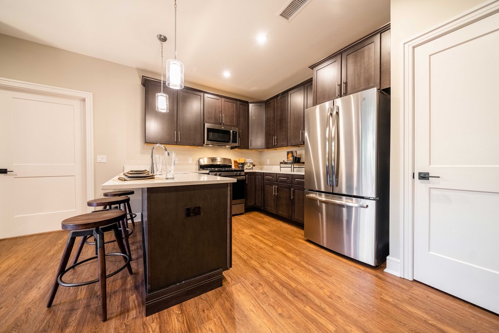 a kitchen with stainless steel appliances and a island with three stools