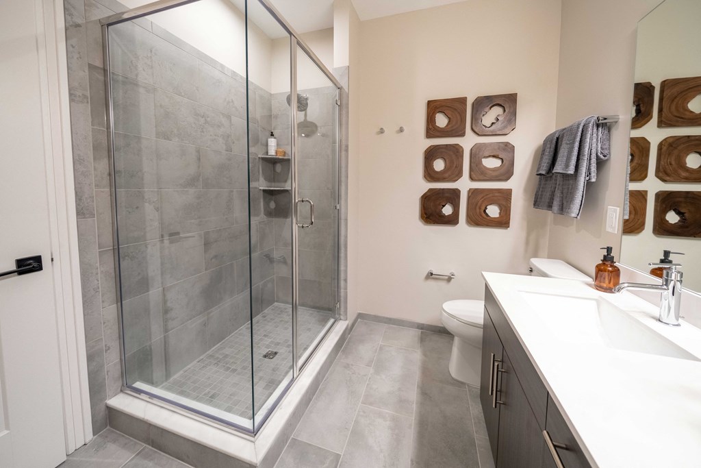 a bathroom with a shower and a sink and a toilet