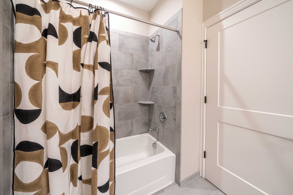 a bathroom with a shower and a tub and a shower curtain