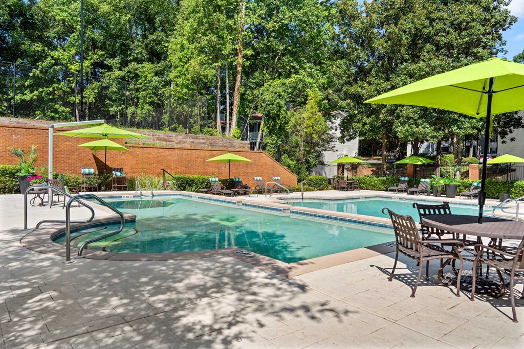 a swimming pool with tables and chairs and umbrellas