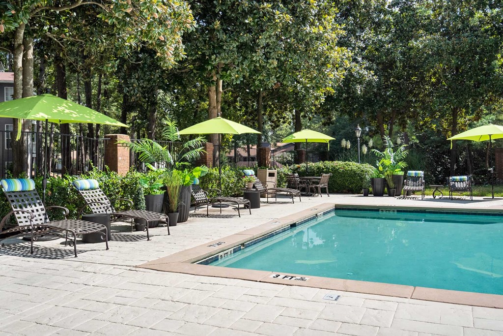 the pool is surrounded by chairs and umbrellas