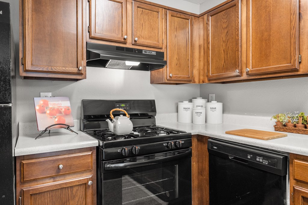 a kitchen with black appliances and wooden cabinets