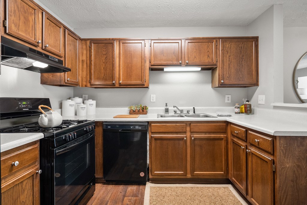 the preserve at ballantyne commons apartment kitchen with black appliances and wooden cabinets