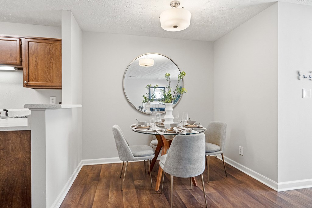 a dining room with a table and chairs and a mirror